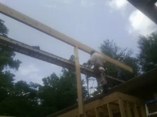 Carpenter setting a ridge beam over a new addition frame — Ice Dam Removal by Roofing Brothers in Whitwell