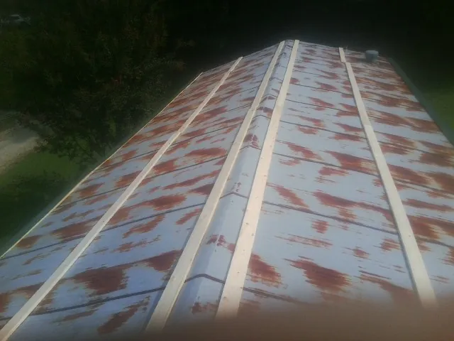 Rusted metal roof panels with new wood purlins before replacement — Storm Damage Roof Repair in Whitwell by Roofing Brothers