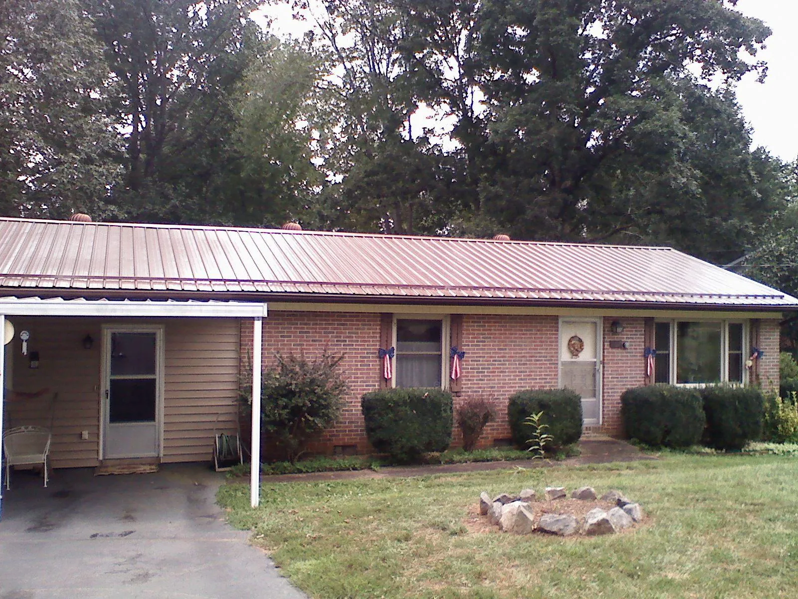 Bronze metal roof and carport on a brick ranch home — Roof Repair work by our crew in Whitwell